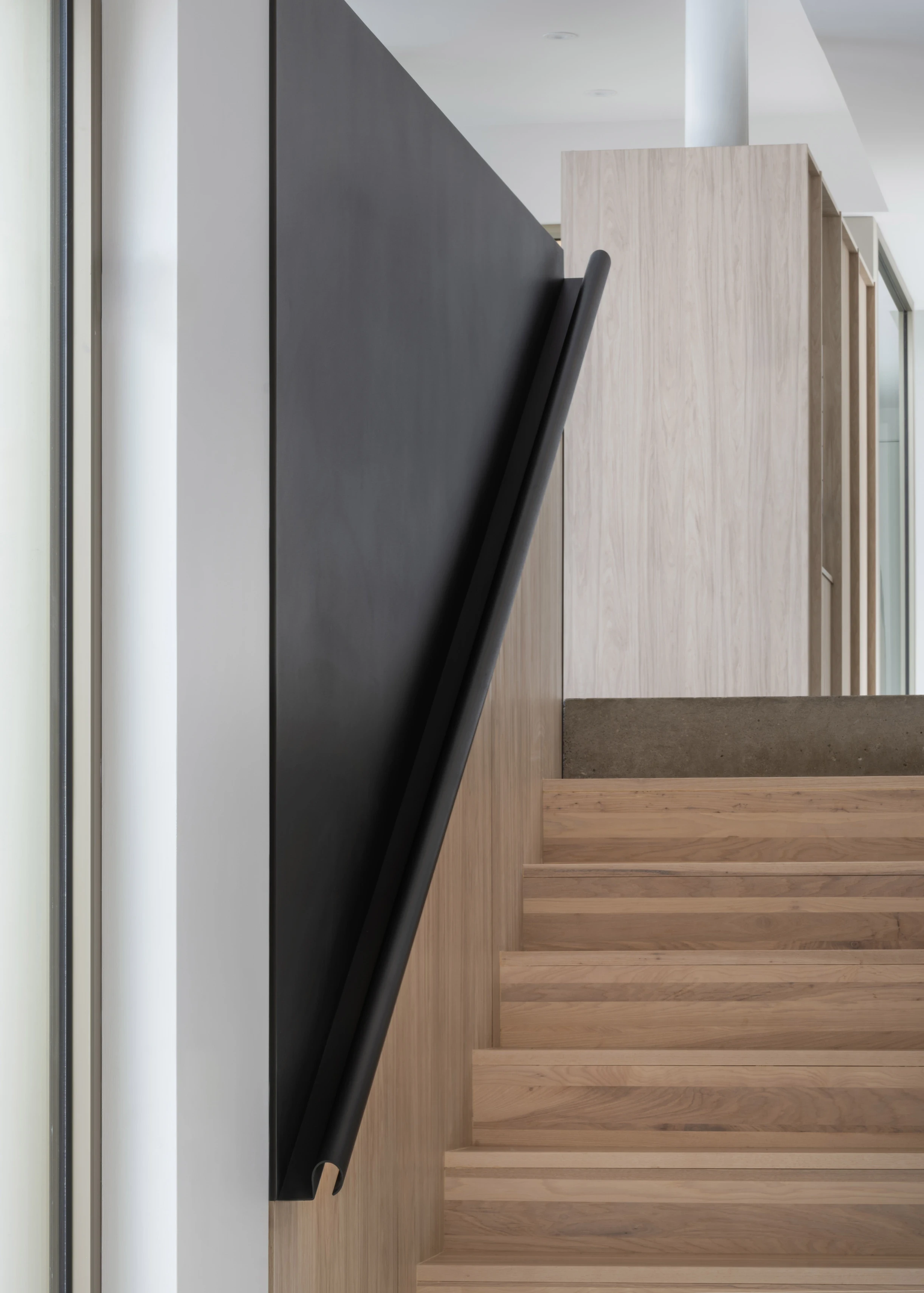 Escalier en bois clair avec garde-corps minimaliste